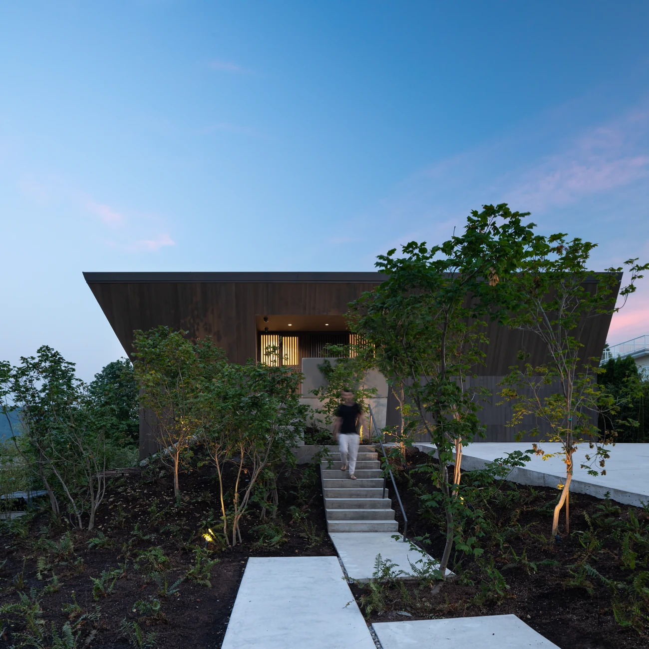 Entrance path and a person beneath Deep Cove’s projecting roof