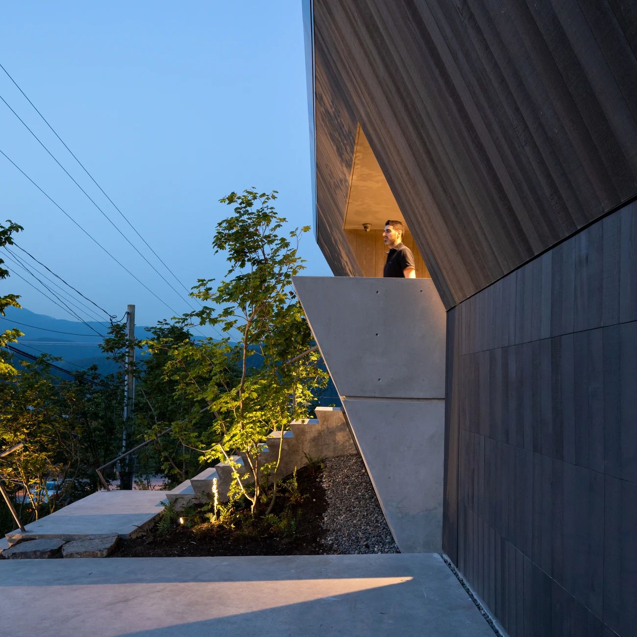 A person at Deep Cove’s side entrance above landscaped concrete steps