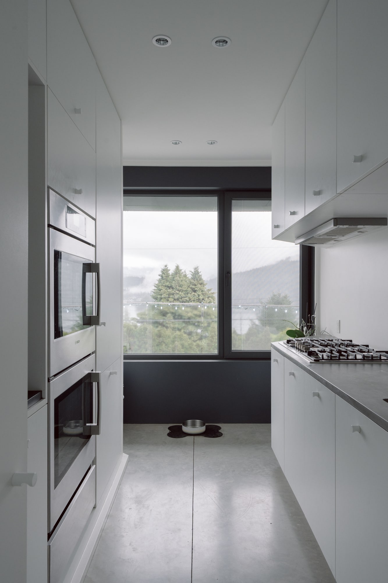 Photography: Shane Hauser Baycrest — Pantry kitchen with cabinetry and a window at the end