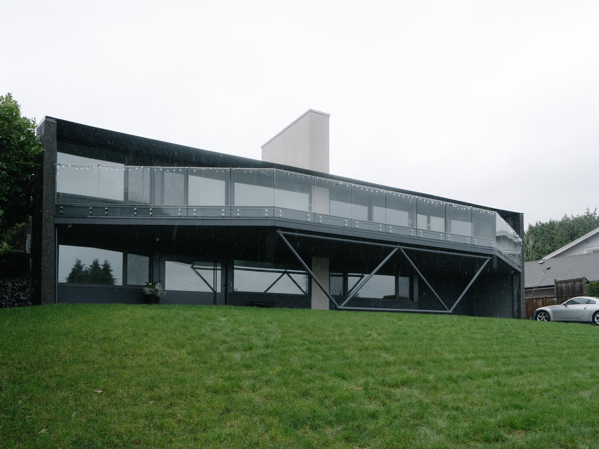 Photography: Shane Hauser Baycrest — Long front elevation with balcony and exposed diagonal supports