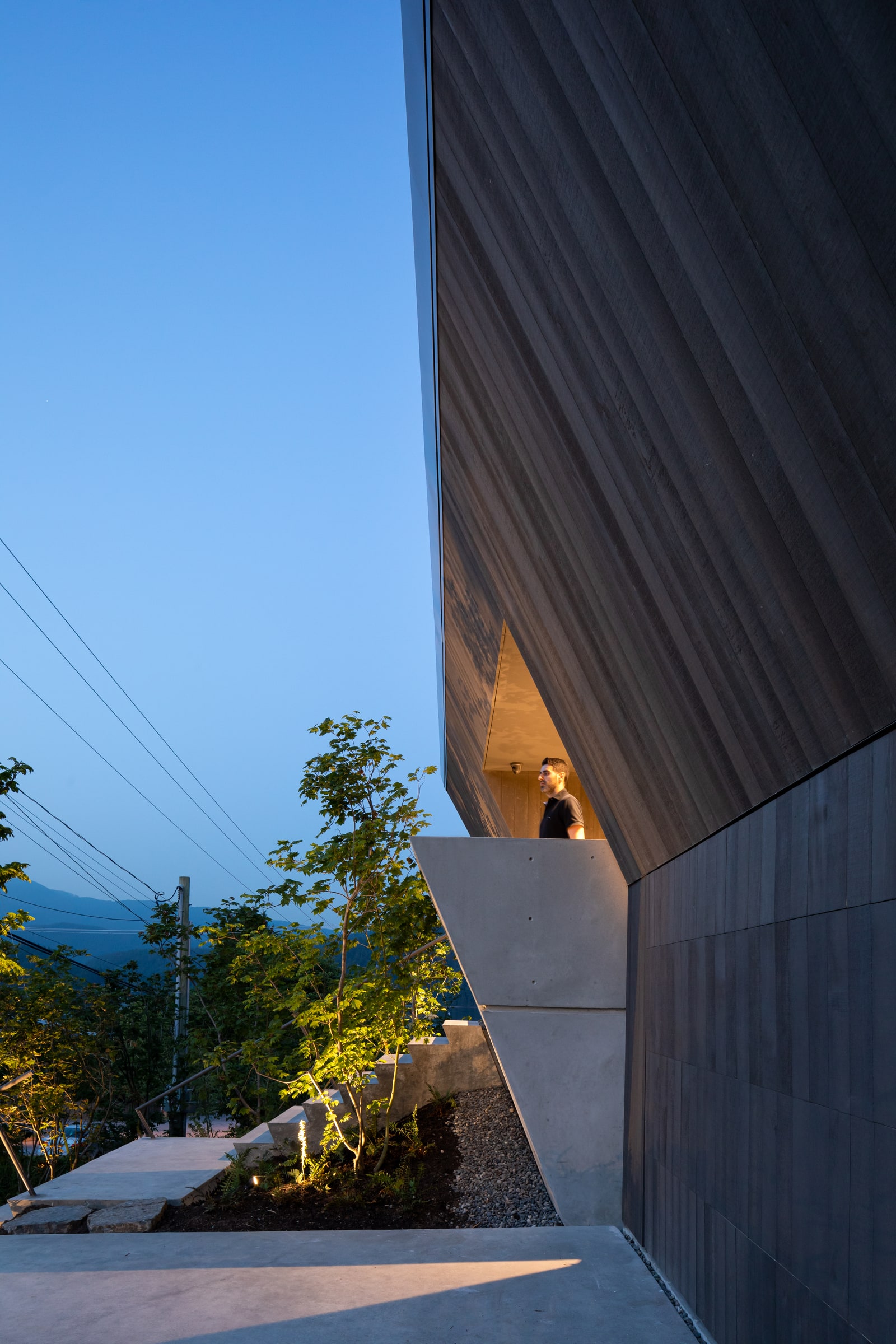 Photography: Ema Peter Deep Cove House — Timber exterior above the sloped garden at dusk