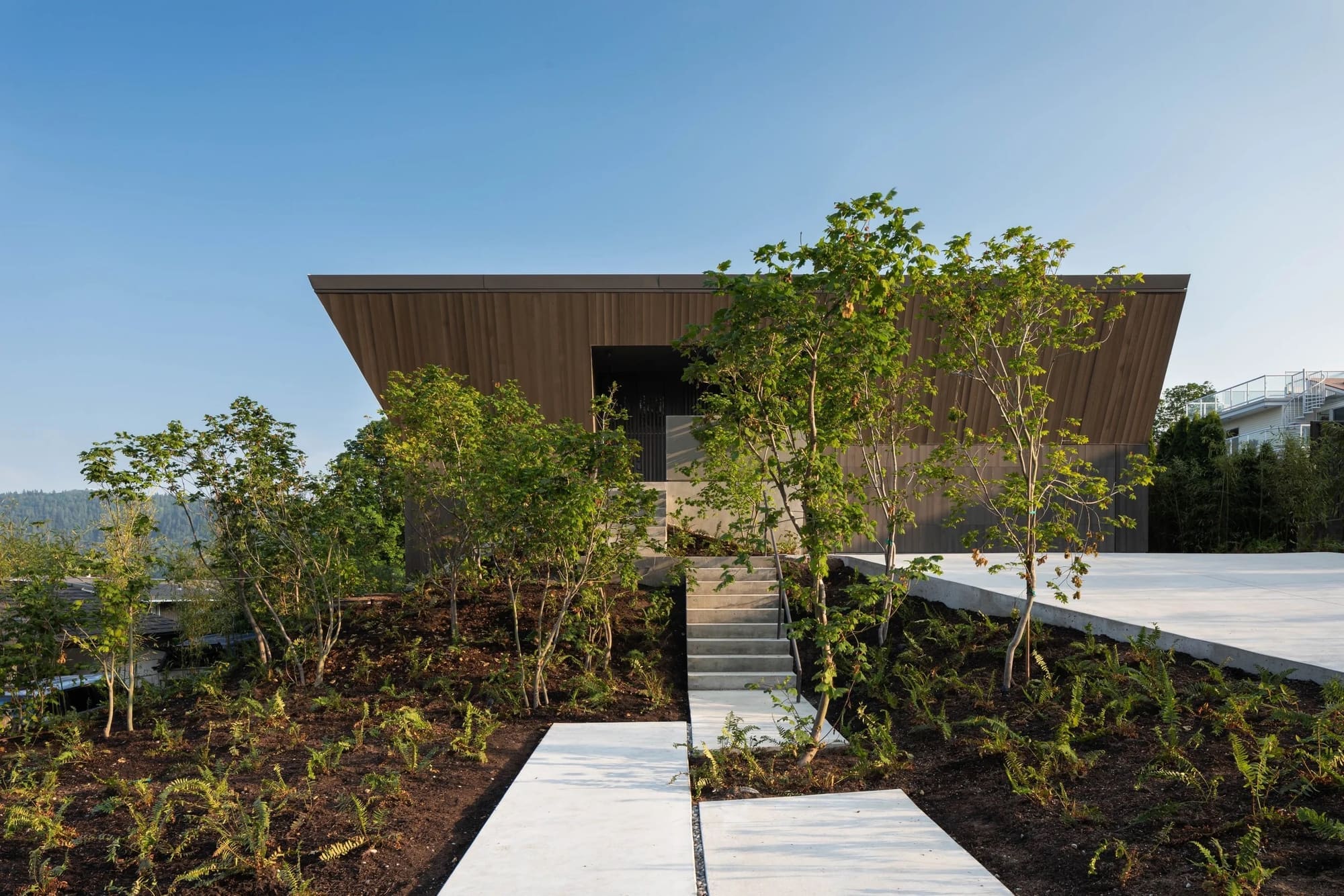 Deep Cove House — Street-facing timber elevation beyond the landscaped entry path