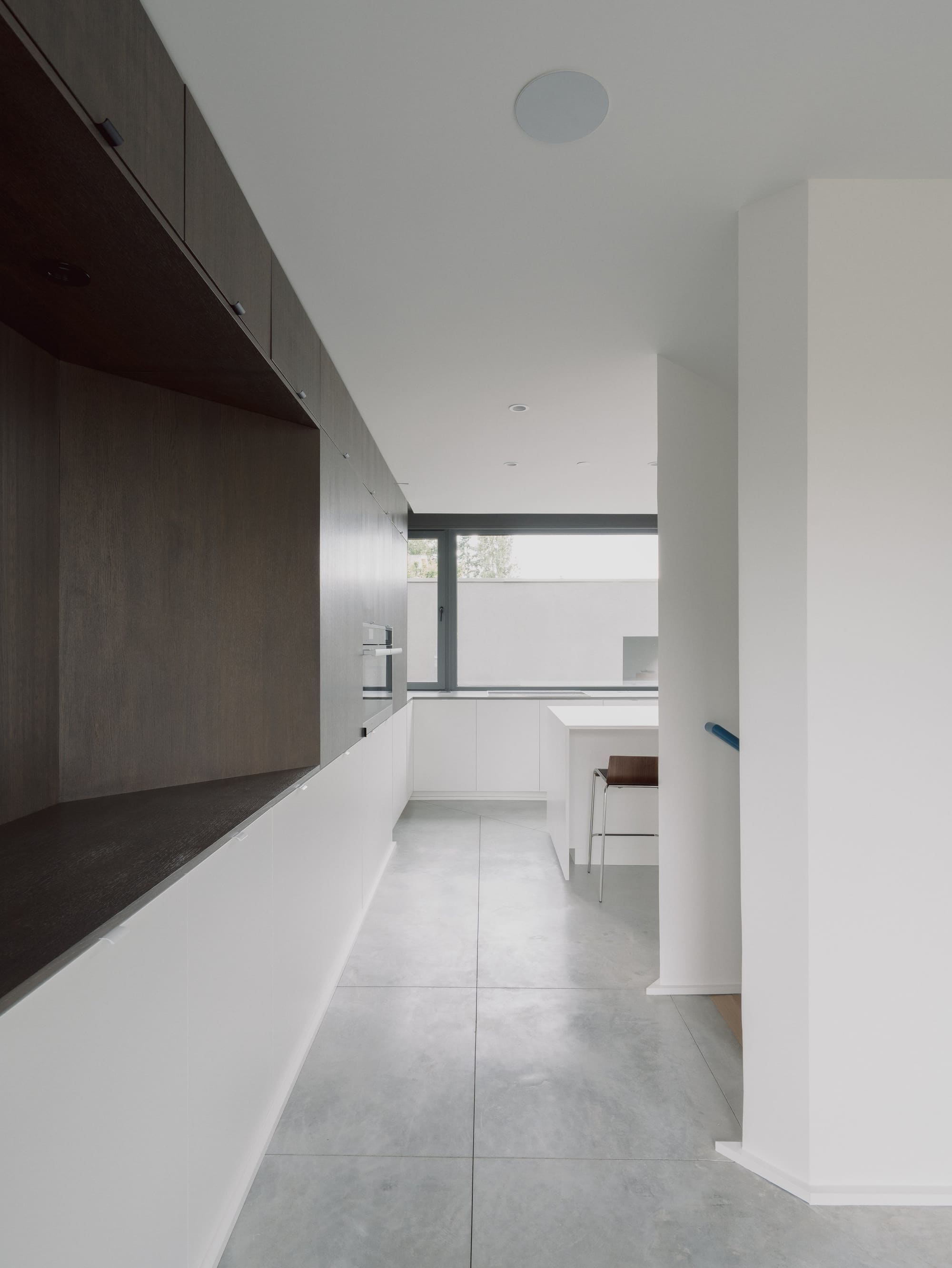 Photography: Shane Hauser Gladstone — Interior corridor with flush cabinetry and concrete floor