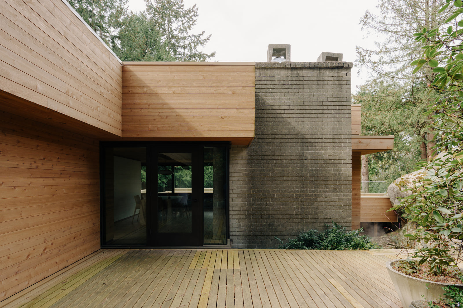 Fells House courtyard with cedar walls and a masonry chimney.