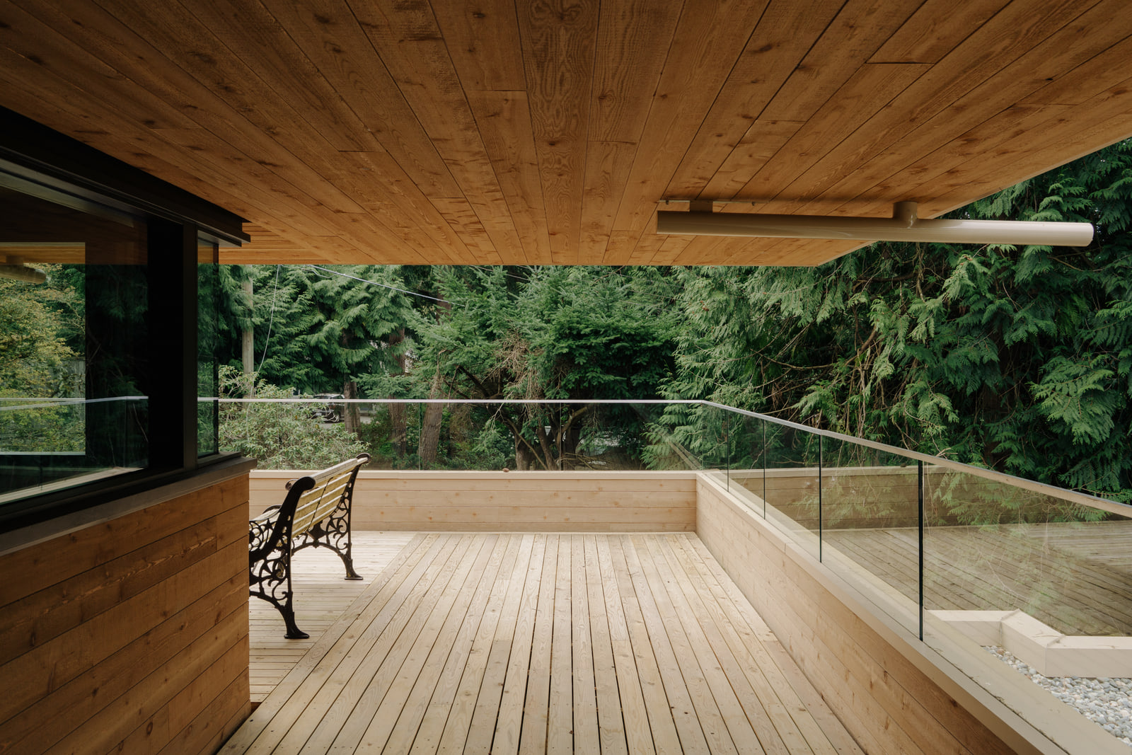 Covered cedar deck at Fells House opening toward the surrounding forest.