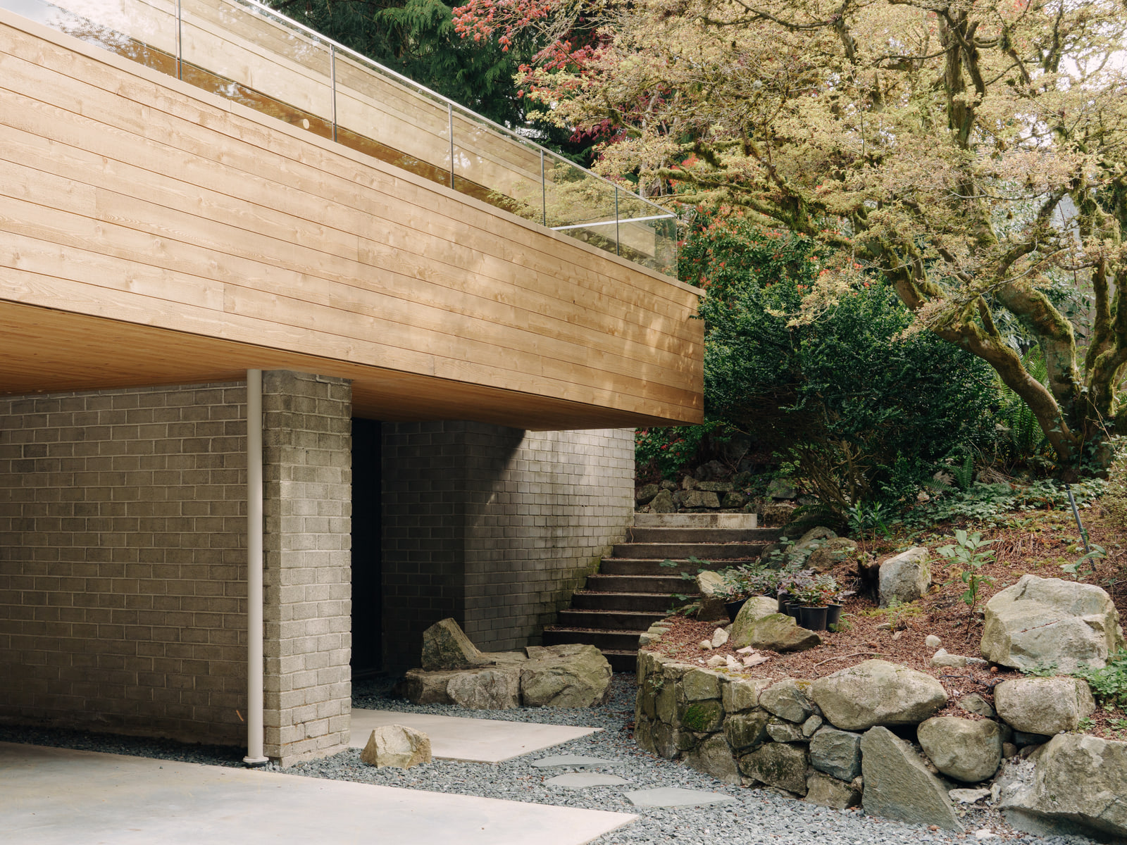 Cedar, masonry and natural rock meeting at the Fells House entrance.