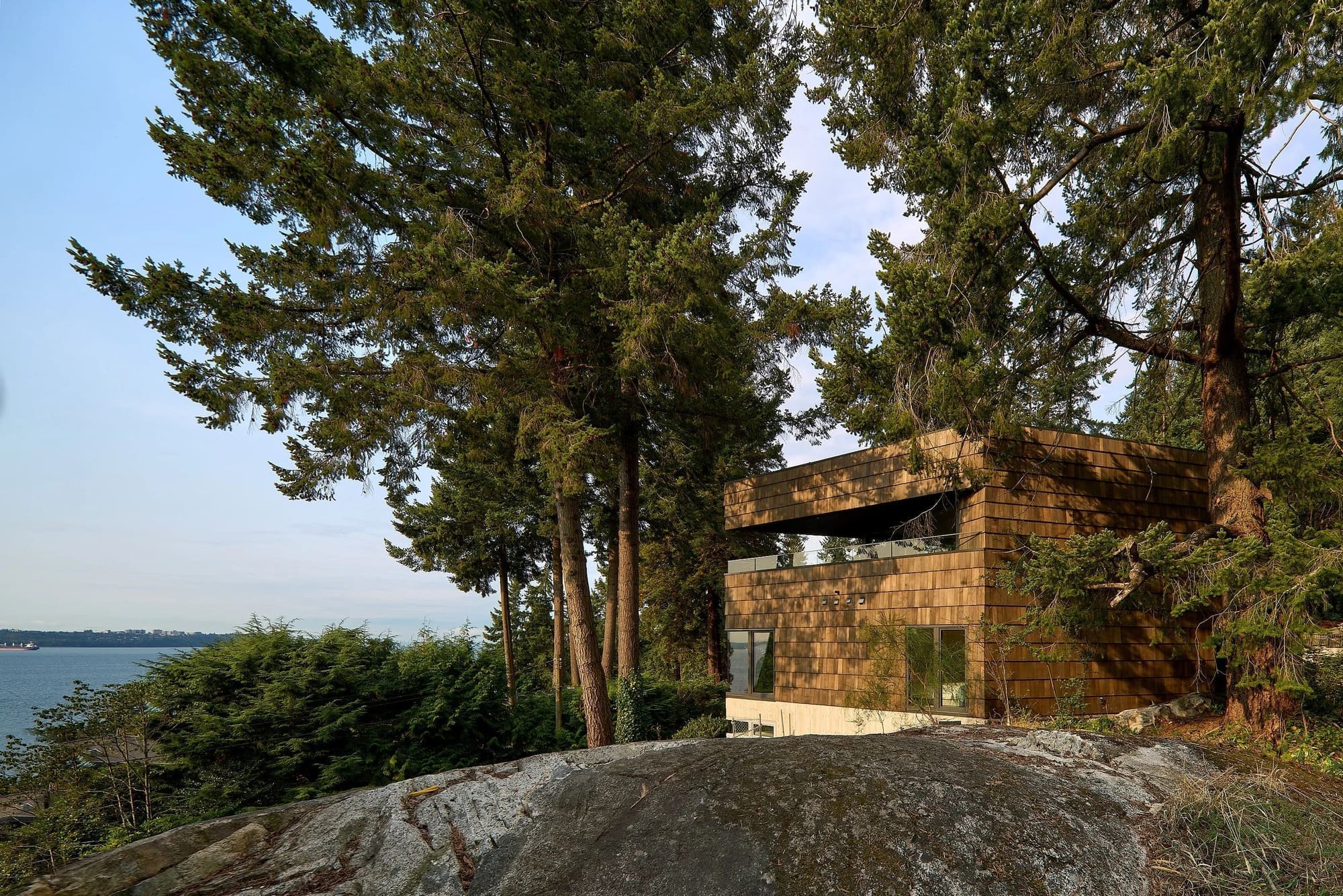 House With Big Shingles — House among coastal trees and granite above the inlet