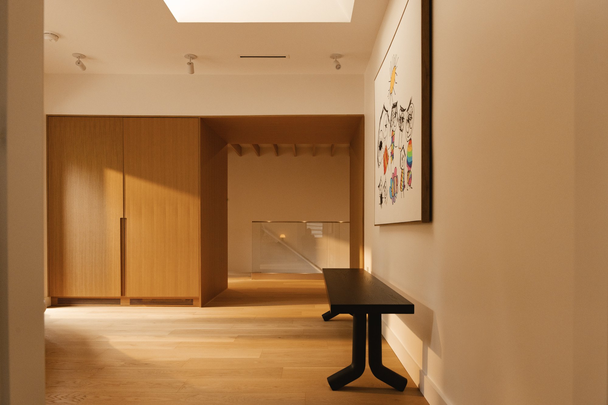 Daylight across the upper hall, timber cabinetry and stair opening.