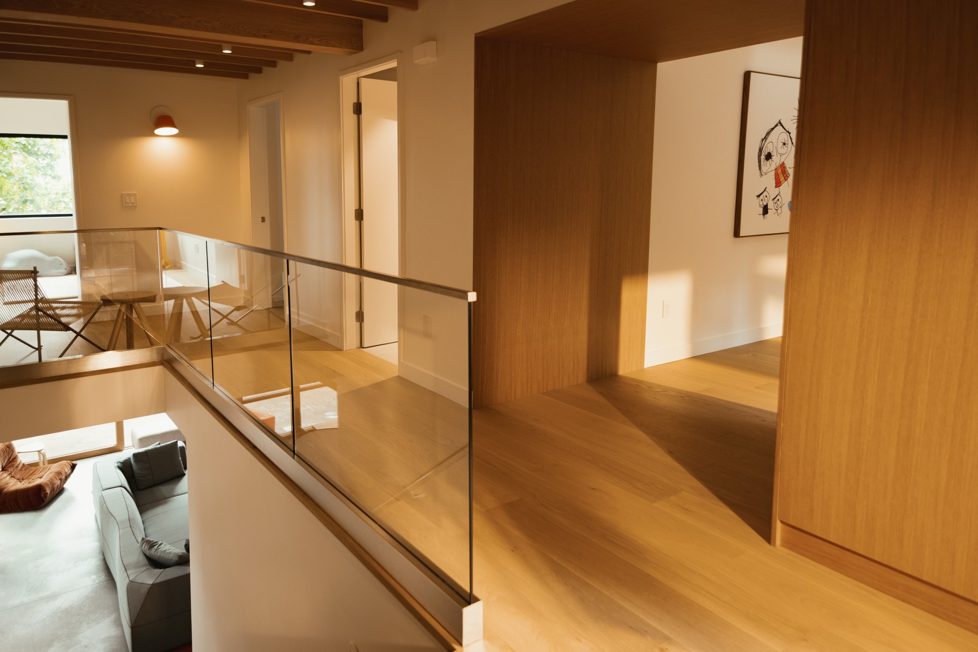 Upper walkway with a glass balustrade and timber portal.